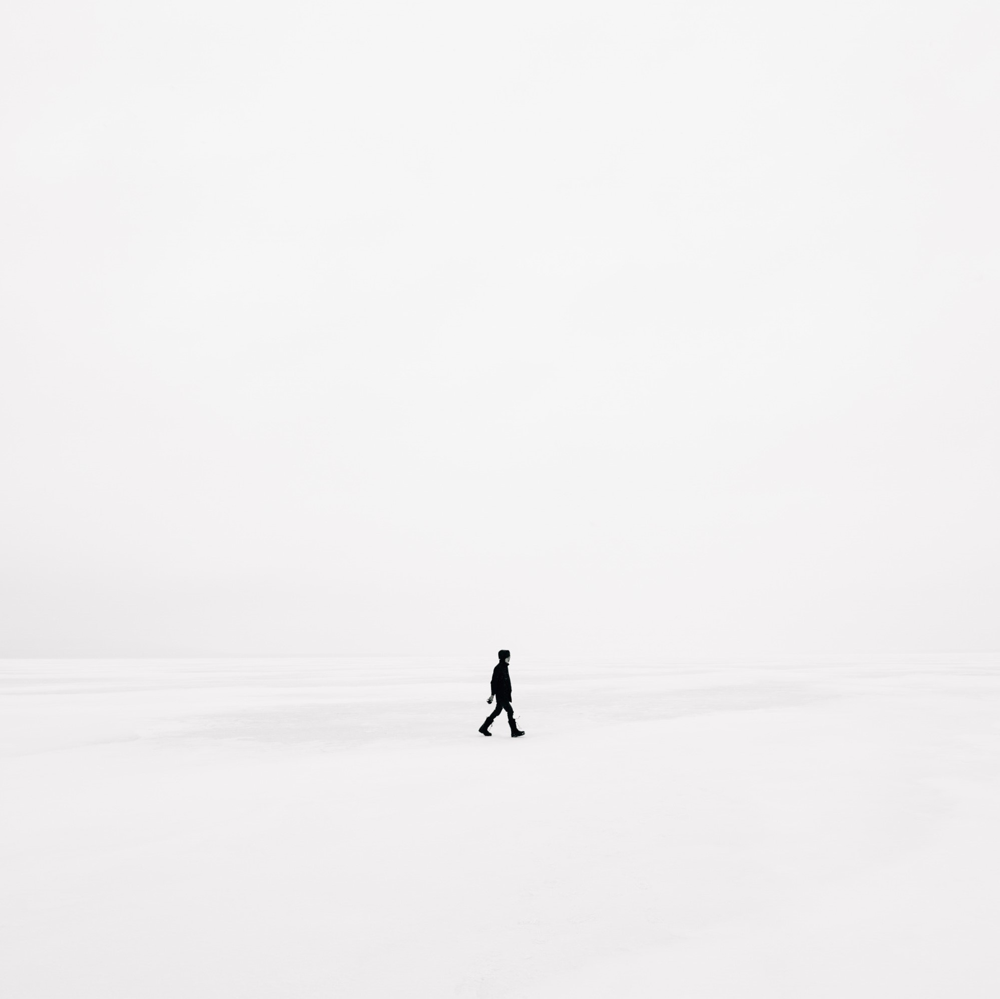 Minimal photo of a person walking in snow